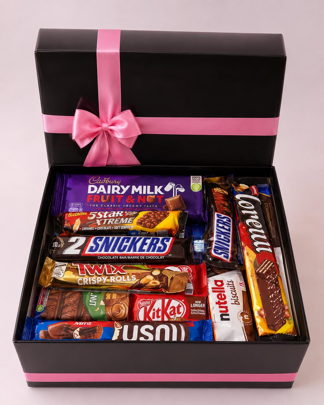 Open black luxury chocolate gift box with a pink satin ribbon, filled with Cadbury, Snickers, Twix, KitKat and Nutella Biscuits.