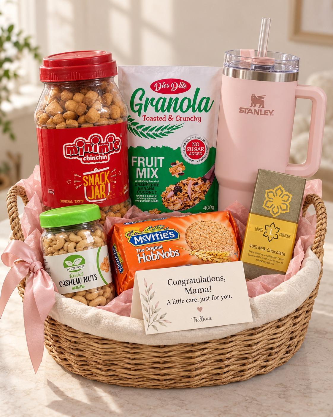 New mum gift basket with Stanley cup, oat biscuits, chin chin, cashew nuts, granola, chocolate and personalised card in a reusable woven basket