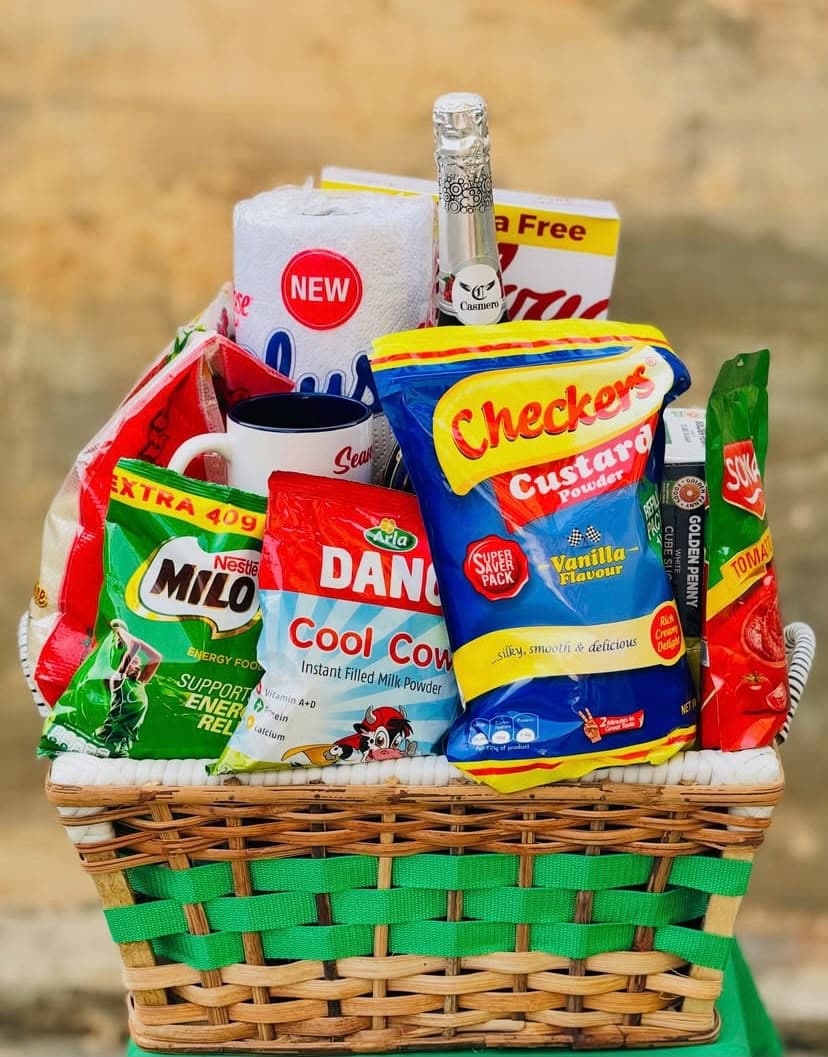 Christmas hamper basket with rice, Milo, milk, custard, cornflakes, Sonia tomato, Dangote sugar, fruit wine and customized mug
