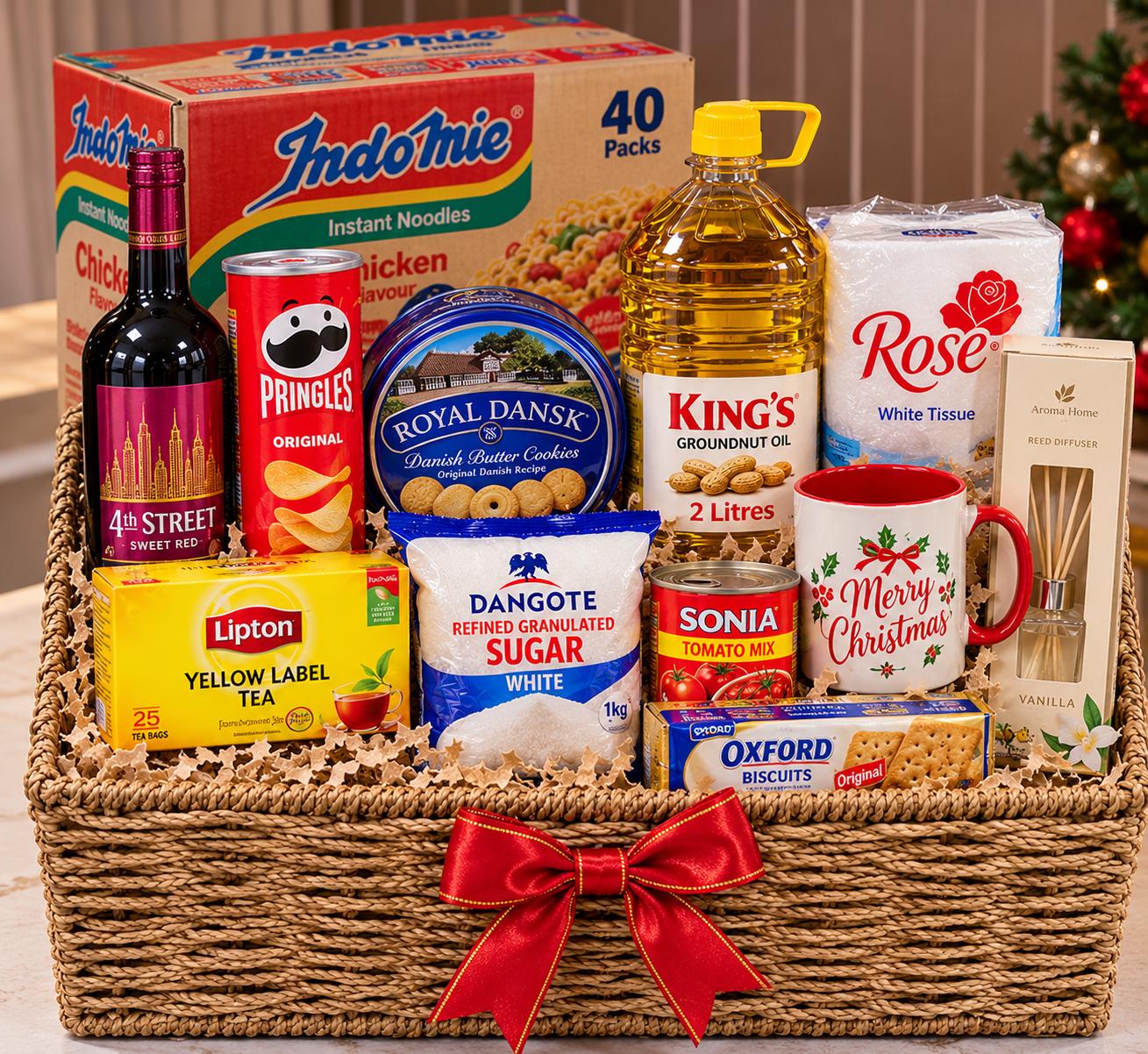 Christmas hamper with wine, carton of noodles, Pringles, cookies, customized mug, groundnut oil, Lipton tea, biscuits, diffuser and tomato